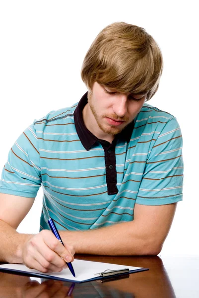 Serious young man sitting at a desk. — Stock Photo, Image