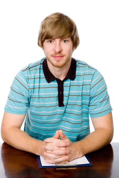 Portrait of a young man sitting behind a desk. — Stock Photo, Image