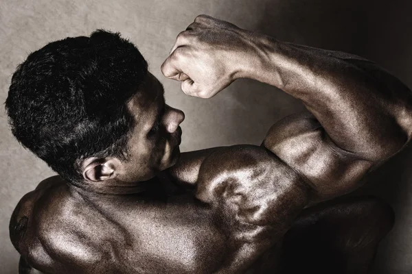 Stark atletisk man visar biceps. — Stockfoto