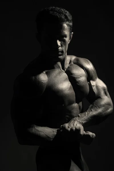 Mladí sportovní muž s nahý trup na tmavém pozadí. — Stock fotografie