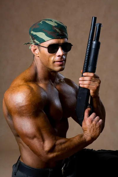 Hombre atlético fuerte con un arma — Foto de Stock