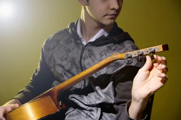 Young man sitting guitar tuning — Stock Photo, Image