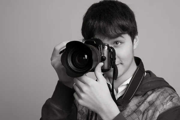 Portrait of cheerful young photographer with a professional came