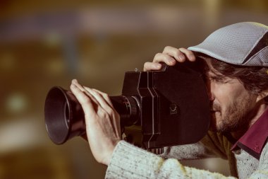 bir adam eski bir film kamerada şapkası