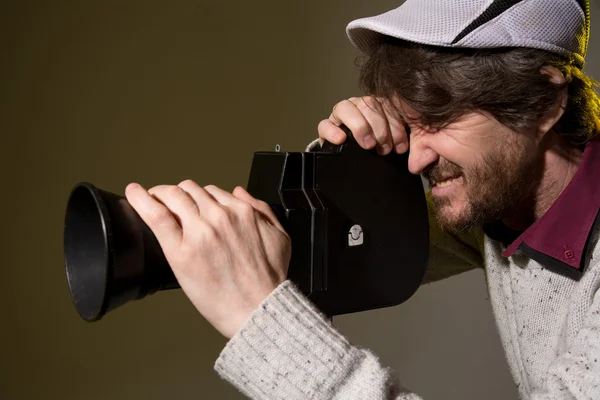 Людина з ретро камерою знімає напругу плівки — стокове фото