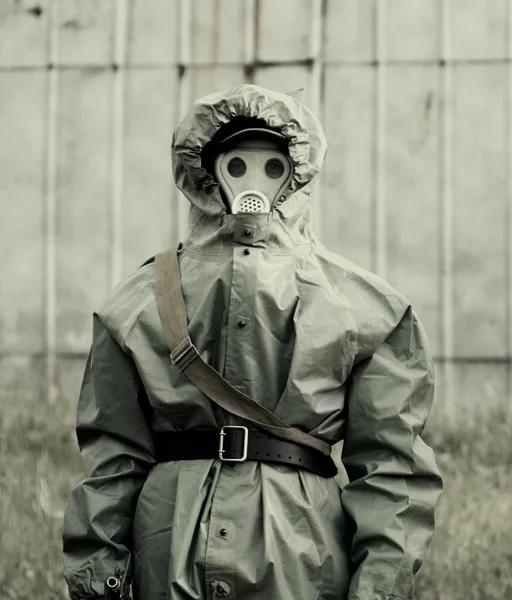 Militaire man in beschermende pak en gas masker buitenshuis — Stockfoto