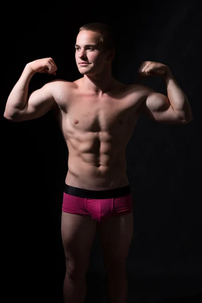 Muskulös kille visar biceps. — Stockfoto