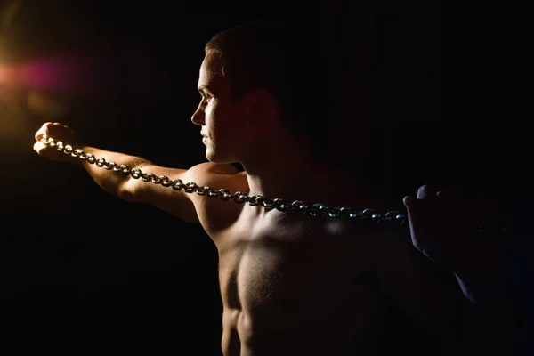Retrato de un joven musculoso con una cadena apretada — Foto de Stock