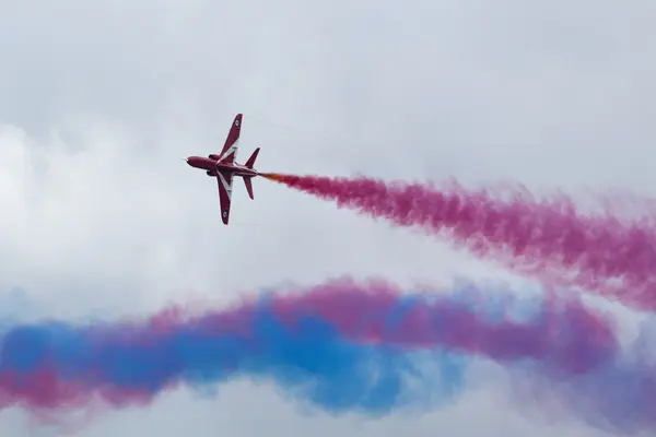 Aerobatic jet with coloured smoke — Stock Photo, Image