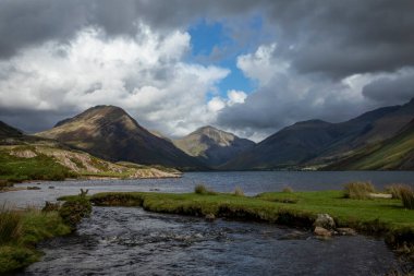 Kontes 'in gagası, güneş ve bulutlarla ıssız sulara akıyor.
