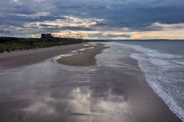 Bamburgh Castle from the beach to the south at sunset with no people elevated view