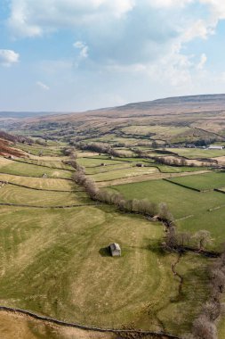 Stone barns and walls in farmland between Angram and Thwaite in Swaledale North Yorkshire high elevated view