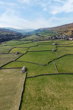 elevated vertical panoramic view of patchwork fields and traditional stone barns at gunnerside in swaledale north yorkshire