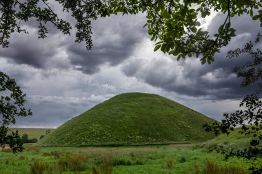 Avebury Wiltshire yakınlarındaki Silbury Hill ağaçların arasından görülüyor.