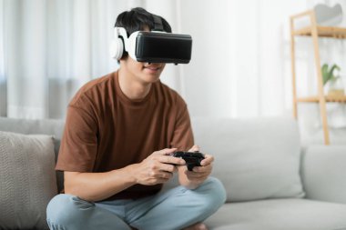 Genç Asyalı oyuncu sanal gerçeklik giyiyor VR deneyimi sırasında havaya dokunuyor gelecekteki ev sahibi teknoloji oyuncusu oyuncu eğlenceli eğlence konsepti