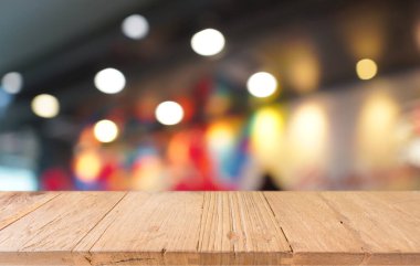 Soyut bulanık arkaplanın önündeki ahşap masa üstü. Metin pazarlama promosyonu için boş tahta masa. arkaplan için boş tahta tablo kopyalama alanı