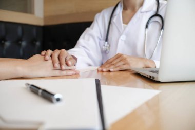Doktorun hastasının elini tutması ve erkek hastasına el konseptine yardım etmesi.