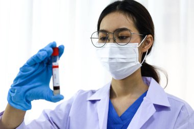 Coronavirus covid-19 'u tutan bilim adamı enfekte olmuş kan örneği tüpü. Kan örneği toplama tüpleri ve şırınga Coronavirus Covid-19 aşı araştırmalarıyla laboratuvardaki kanın DNA testi.