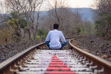 Güneşli bir yaz gününde Mhow, Indore, Madhya Pradesh yakınlarındaki Kalakund dağ köyünde meditasyon pistinde oturan bir adam. Hint köyü.
