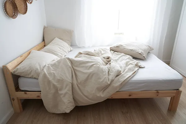 Un lit à l'intérieur de la chambre. Vue de dessus. Le lit n'est pas fait. Couleur beige — Photo