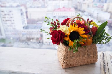 Kırmızı güllerden, ayçiçeklerinden ve yeşil yapraklardan yapılmış güzel sonbahar çiçekleriyle dolu bir sepet. Tatil konsepti. Boşluğu kopyala