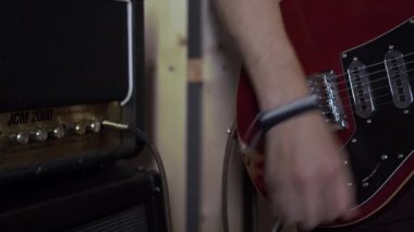 Yakın çekim ses yükselticisi, ses sistemi. Ses konser ekipmanı. Bir adam elektronik gitarı akort ediyor.