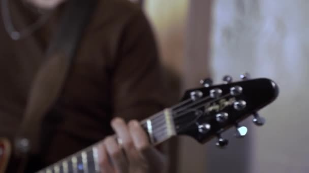 Κοντινό πλάνο ενός άνδρα που παίζει έντονα μια ηλεκτρονική κιθάρα. — Αρχείο Βίντεο