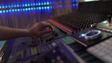 Stüdyoda profesyonel karıştırma konsolu, sesi kontrol eden bir adam, LED arka farlı