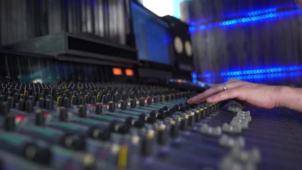 Professionelles Mischpult im Studio, weibliche Hand steuert den Ton, mit LED-Hintergrundbeleuchtung — Stockvideo