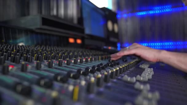 Professionell mixningskonsol i studion, kvinnlig hand styr ljudet, med LED-bakgrundsbelysning — Stockvideo