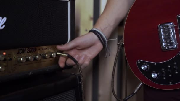 エレキギター用のサウンドアンプをチューニングする男のクローズアップ。音響設備. — ストック動画