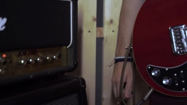 전자 기타에 음향 증폭기를 튜닝하는 남자의 근접 사진. 음향 연주회 장비. — 비디오