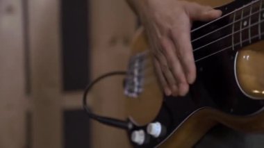 Bir adam yoğun bir şekilde elektronik gitar çalar, yakın plan, ses sistemi. Ses konser ekipmanı.