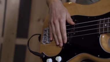 Bej elektronik gitar, yakın çekim, ses sistemi. Ses konser ekipmanı. Bir adam elektronik gitarı akort ediyor.
