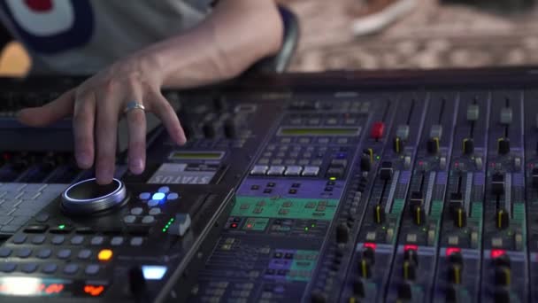 Primer plano. Consola de mezcla profesional en el estudio, una mano mans controla el sonido, con retroiluminación led — Vídeo de stock