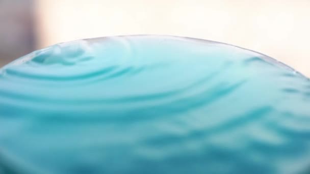 Een druppel water met golven, in slow motion. Een druppel water viel in de vloeistof en maakte een plons op het oppervlak. — Stockvideo