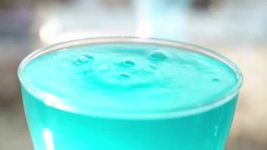 Turkuaz suyla bardağa su dök. Ağır çekimde, bir bardak suyun içine bir su dökülür ve yüzeyde bir sıçrama yapar..