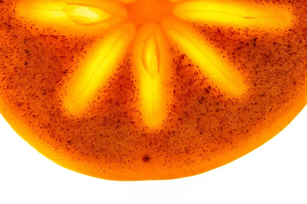Gros plan d'un morceau de kaki frais mûr, une demi-tranche ronde sur un fond blanc isolé.Lumière vive au milieu du fruit. — Photo