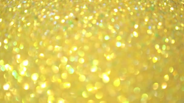 Focusing the flickering background. Blurred texture of golden radiance. Seamless texture with yellow gold sequins. — Stock Video