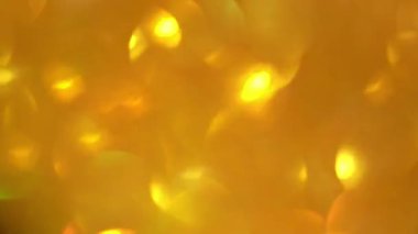 Titreyen arka planda hızlı hareketler. Altın parıltının bulanık dokusu. Sarı altın pullu pürüzsüz bir doku..