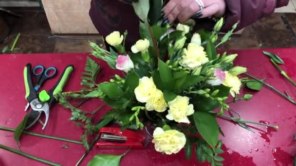Para penjual bunga membuat komposisi dari warna yang berbeda. Produksi karangan bunga, lokakarya bunga. Orang-orang dalam proses kerja. — Stok Video