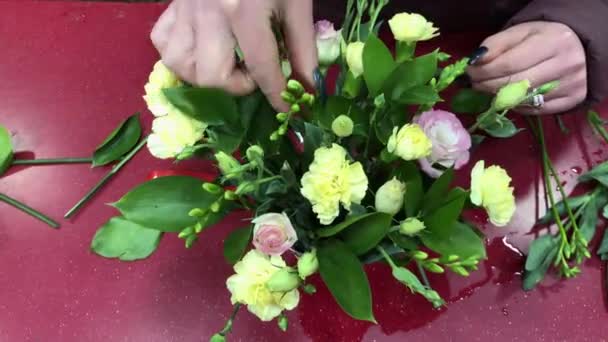 Producción de ramos, taller de flores. El florista hace una composición de diferentes colores. Personas en proceso de trabajo. — Vídeos de Stock
