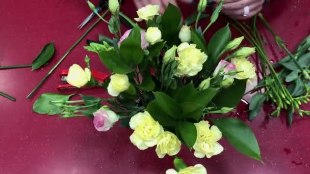 Production of bouquets, flower workshop. The florist makes a composition of different colors. People in the process of work. — Stock Video