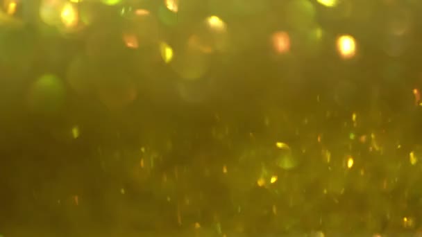 Focusing the flickering background. Blurred texture of golden radiance. Seamless texture with yellow gold sequins. — Stock Video