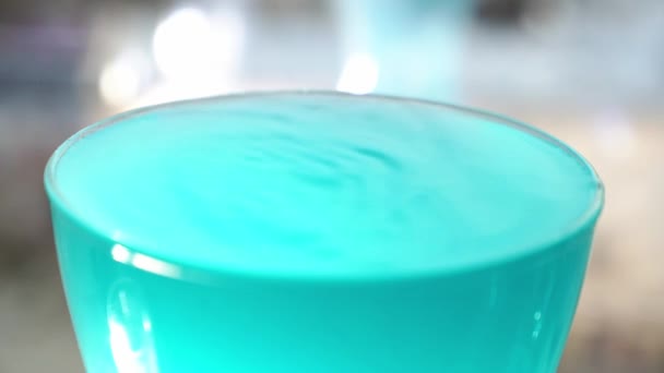 På en alkoholhaltig cocktail, mod gör ett stänk från en droppe på ytan. I slow motion faller en droppe av drycken ner i glaset. — Stockvideo