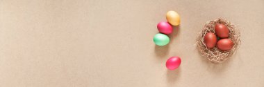 Yuvalı bir pankart ve bej arka planda Paskalya yumurtaları. Üst Manzara. Kopyalamak için boşluk