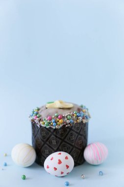 Dekorlu bir pastanın arka planında desenli üç beyaz Paskalya yumurtası. Mavi zemin üzerinde Ortodoks Paskalyası Kopyalanacak bir boşluk