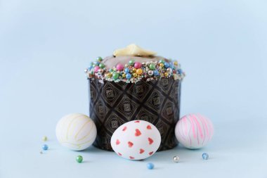 Mavi arka planda üç beyaz Paskalya yumurtası ve bir pastaya yakın plan. Kopyalanacak bir yeri olan Ortodoks Paskalyası