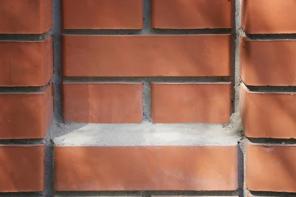 Podio hecho de pared de ladrillo naranja. Fondo grunge de una pared de ladrillo con un hueco en el interior. —  Fotos de Stock