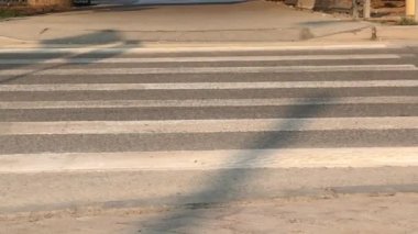 Yaya geçidinden geçen bir bisikletlinin yakın çekimi. Bir grup insan yaya geçidinden karşıya geçiyor..